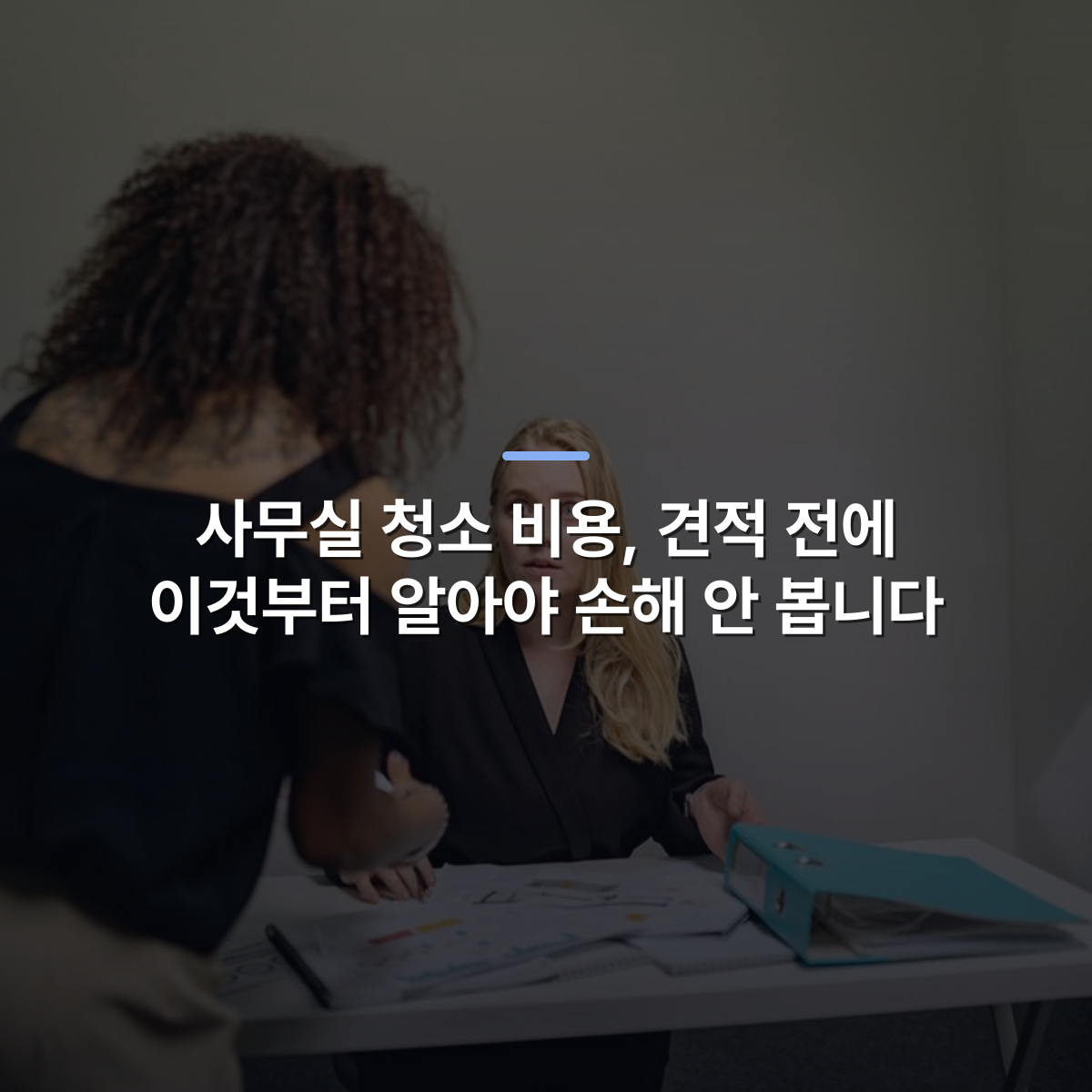 사무실 청소 비용, 견적 전에 이것부터 알아야 손해 안 봅니다 · 사진: Two women discussing work at an office desk with documents and a binder, showcasing teamwork and communication.